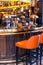 Stylish interior bar, in vintage style. Orange chairs, glasses, lamps and designer decorations.