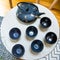 Stylish Interior Decoration of a Cast Iron Teapot with Dragonfly Decoration and Round Cups on Geometric Tables