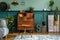 Stylish interior design with retro wooden cabinet, chair, elegant sofa, plants, cube, stool, decoratnion, poster.