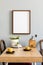 Stylish interior of kitchen space with wooden table with mock up photo frame, design chairs, decoration and furniture.