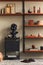 Stylish interior of living room with design black statue, wooden bookcase, pendant lamp, carpet decor, picture frames.