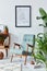 Stylish interior of living room with design wooden shelf, retro armchair, plants, mock up poster map, decoration, book, cacti.