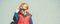 Stylish kid in trendy sunglasses. Kids fashion. Cute little blondy boy in red jacket standing over grey wall outdoors in sunny da