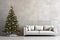 Stylish light leather sofa with pillows next to a decorated Christmas tree against a gray concrete wall. Minimalistic design of a