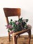 Stylish lilac purple bouquet on rustic wooden chair in room. Fresh spring lilac flowers bouquet on chair, countryside still life.