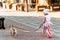 Stylish little girl walks with a dog along a city street