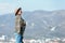 Stylish lonely woman in a hat against a background of mountains.