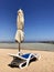 Stylish lounger in yellow sand to sun sunbed on beach in summer under open sky