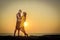 Stylish loving couple hugging each other on the beach at sunset. Man and woman in holiday honeymoon trip