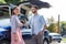 Stylish loving couple standing near their nice luxury car