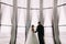 Stylish luxury bride and groom holding hands at gorgeous window on the background of interior in modern building