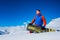 Stylish male athlete snowboarder sits on the snow