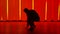 Stylish male break dance dancer performs a spin on the floor in a dark studio against the backdrop of red and yellow