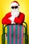 Stylish male santa posing with a deckchair
