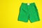 Stylish male swim trunks on color background, space for text. Beach object