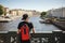 Stylish male tourist with backpack looking to cityscape on the embankment of Griboyedov canal in St. Petersburg, Russia