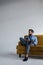 stylish man in blue trendy suit holding smartphone and sitting