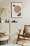 Stylish and modern beige living room interior composition with mock up poster frame, beige wooden sideboard, armchair and boho.