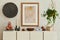 Stylish and modern beige living room interior composition with mock up poster frame, beige wooden sideboard, plant and boho