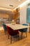 Stylish modern kitchen interior, studio. Large table with velvet chairs. Zone in living room, dining room, designer wood veneer