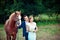 Stylish newlyweds stand near horse among the forest