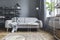 Stylish nordic living room with design grey sofa, coffee table, white lamp, bookstand, furniture, carpet, plant.