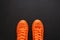 Stylish orange sneakers on dark background