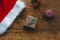 Stylish packaged Christmas gift box, Santa Claus hat and a sprig of spruce on a rustic wooden table. Atmospheric image. Merry