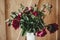 Stylish peony bouquet in white ceramic vase  on rustic wooden background. Red and pink peonies rural still life. Hello spring