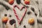 Stylish peppermint candy cane in heart shape and pine cones and