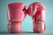 Stylish Pink boxing gloves on a light background. Concept of femininity in sports, fashionable athletic equipment, and