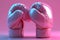 Stylish Pink boxing gloves on a pink background. Concept of femininity in sports, fashionable athletic equipment, and