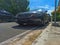 Stylish Presence: A Parked Black Luxury Car on the Sidewalk During Daytime