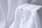 Stylish presentation of necklace on white cloth. Space for text