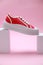 Stylish presentation of red classic old school sneaker on pink background