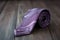 Stylish purple silk necktie on wooden. Generate Ai