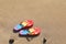 Stylish rainbow flip flops on sand at beach, above view. Space for text