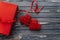 Stylish red present and two heart ribbons flat lay on black rust