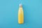 Stylish reusable eco-friendly thermo stainless steel yellow bottle on light blue background