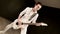 Stylish rhythm guitarist with different eyes in white clothes on a black background expressively playing the white