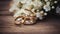 Stylish rings, flowers on wooden table background. Letters from the bride and groom