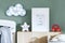 Stylish scandi childroom with wooden mock up photo frame, wooden toys, boxes, blocks and accessories Bright and sunny interior