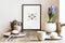 Stylish scandi interior design of kitchen space with small table with mock up frame, plant, cups of tea and tasty dessert.