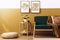Stylish scandinavian interior of living room with design green velvet sofa, gold pouf, wooden furniture, plants, carpet, cube.