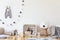 Stylish scandinavian kid room with copy space, toys, teddy bear, plush animal, natural pouf and children accessories.