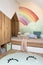 Stylish scandinavian kid room with toys, teddy bear, plush animal toys, furniture, kid accessories. Modern interior with rainbow.