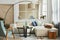 Stylish scandinavian living room interior with neutral modular sofa, armchair, design coffee table, window, floor lamp, plant.