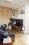 Stylish scandinavian living room open space with design sofa and bookstand. Bright and sunny room with plants, poster wall.