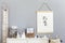 Stylish scandinavian nursery interior with hanging mock up poster, natural toys, teddy bears, children`s accessories and design