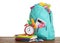 Stylish schoolbag with different stationary and alarm clock on wooden table